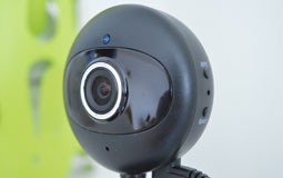 Kleine Grafik zum Thema Webcams mit einer schwarzen Webcam vor grün-weißem Hintergrund