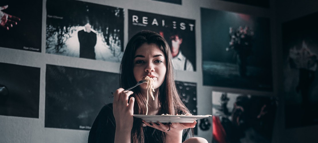 Banner zum Thema Filmplakate mit einem jungen Mädchen, dass Spaghetti isst und im Hintergrund sind viele Filmposter